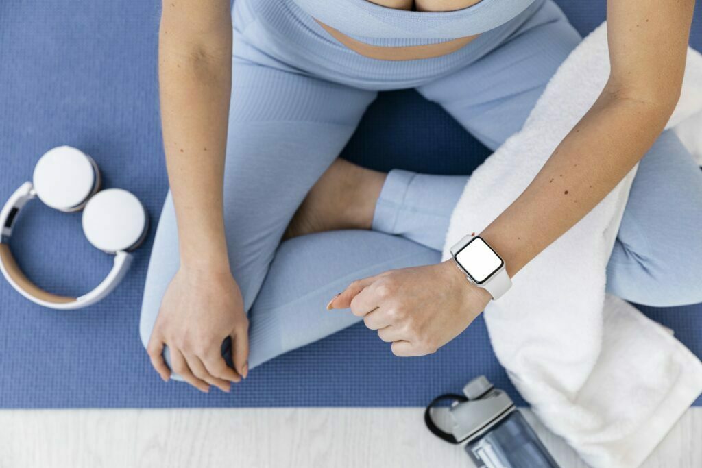 Kobieta ćwiczy, ma zegarek i oblicza zapotrzebowanie kaloryczne. Ile kalorii potrzbuję?